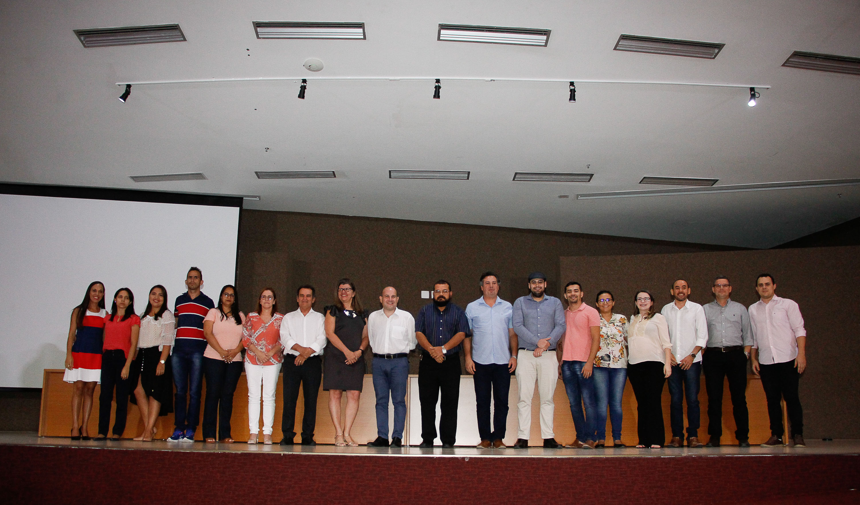 prefeito e pessoas em pé em cima de palco